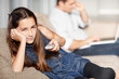 Little girl holding remote control while father in background