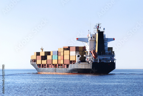 Photo: cargo ship sailing in still water cargo ship sailing in still water