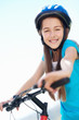 Playful little girl riding bicycle against sky