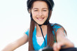 Little girl wearing helmet while riding her bicycle against sky
