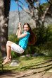 Playful little girl swinging on a rope in playground
