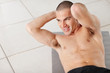 Photo: Happy man lying on mat and exercising with hands behind head Happy man lying on mat and exercising with hands behind head