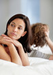A mature couple lying in bed with facing opposite sides