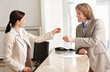 Mature receptionist giving keys to a happy mature businessman