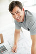 Happy young male architect looking at you while working