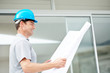 Happy young male architecture reading blueprint