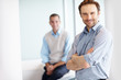 Happy business man with hands folded and a man in blurred
