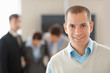 Smiling young man with his associates in background