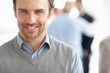 Happy middle aged man with people in blurred background
