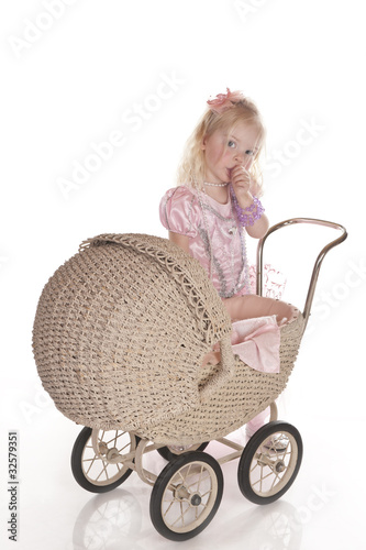 Photo: little girl dressed playing with baby carriage little girl dressed playing with baby carriage