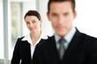 Smart young businesswoman with a male colleague in front