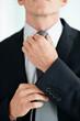 Closeup of a well dressed business person adjusting his tie