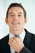 Handsome young business man adjusting tie