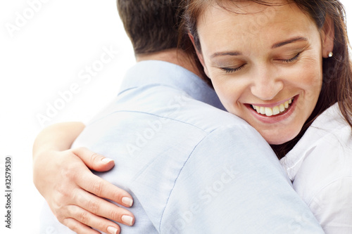 Photo: Smiling young couple hugging on white background Smiling young couple hugging on white background