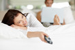 Woman lying on bed and  watching television