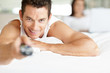 Guy lying on bed and watching television
