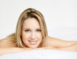 Pretty woman lying relaxed in bed with a smile