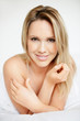 Tempting blond female in bed with a smile
