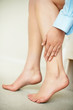 Low section of a female touching her legs