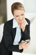 Young business woman reading message on mobile phone