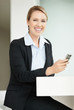 Cheerful attractive business woman holding a mobile phone