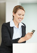 Happy business woman reading message on cell phone
