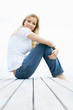 Cute smiling female sitting on a wooden porch