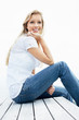 Smiling blond female sitting alone on a porch