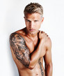 Shirtless man showing off his tattooed arm