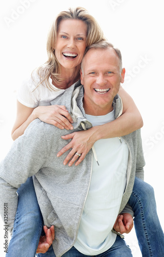 Photo: Playful mature man giving piggyback ride to woman Playful mature man giving piggyback ride to woman