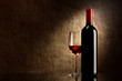 bottle with red wine and glass on a old stone