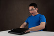 young asian man got his hands stuck in laptop computer