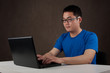 young asian man working on his laptop computer