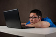 bored and tired young asian man working with his computer