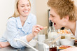 Breakfast happy couple woman feed man cereal Breakfast happy couple woman feed man cereal