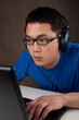 closeup of young asian man playing games on laptop computer