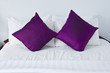 Hotel bedroom interior with double purple pillows