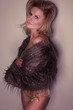 Sexy lady wearing short fur coat isolated on white
