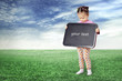 The girl with a board for drawing on a meadow