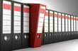 Red ring binder sticking out from a row of dark binders