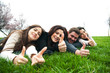 Group of young people relaxing and lying on the grass
