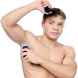 Muscular man's using an antiperspirant