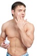 Man putting on cream lotion on face