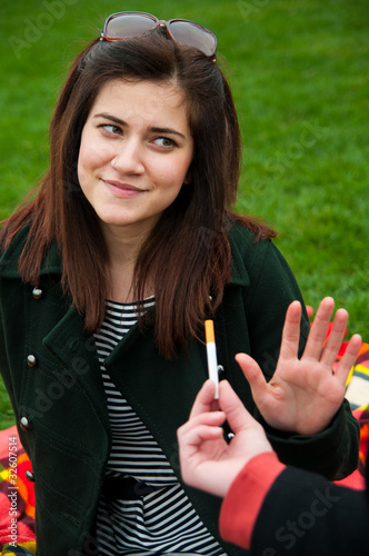 Photo: Young female reject smoking offer Young female reject smoking offer