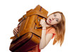 Redhead girl with heavy old suitcase.