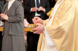 Foto: Catholic priest granting the Communion Catholic priest granting the Communion