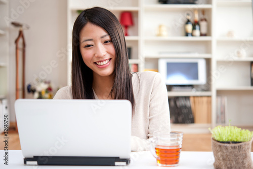 Photo: beautiful asian woman using a laptop computer beautiful asian woman using a laptop computer