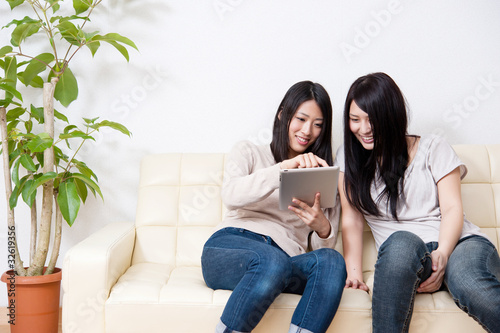 Photo: beautiful asian women relaxing on the couch beautiful asian women relaxing on the couch