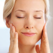 Beautiful young woman pampering her face