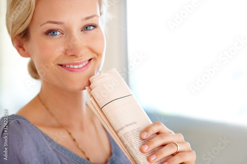 Photo: Beautiful young lady holding newspaper Beautiful young lady holding newspaper